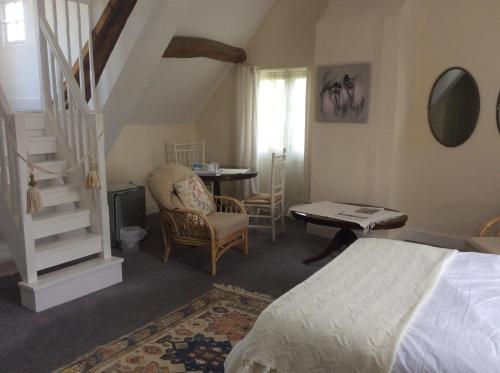 1 dormitorio con cama, mesa y escalera en The Old Mill, en Shipston on Stour
