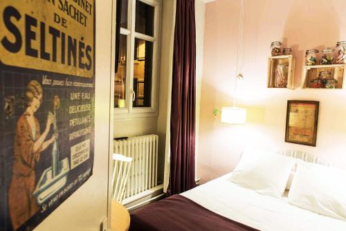 a bedroom with a bed and a poster on the wall at Hotel Auberge des Remparts in Laval