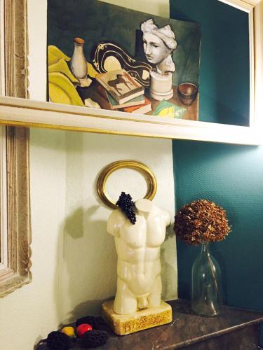 a shelf with a statue of a woman and a mirror at Hotel Auberge des Remparts in Laval