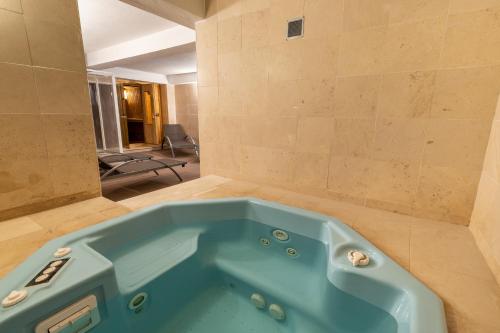 Estoril Luxury Suites & Spa - Cascais في استوريل: حمام مع حوض أزرق في الغرفة