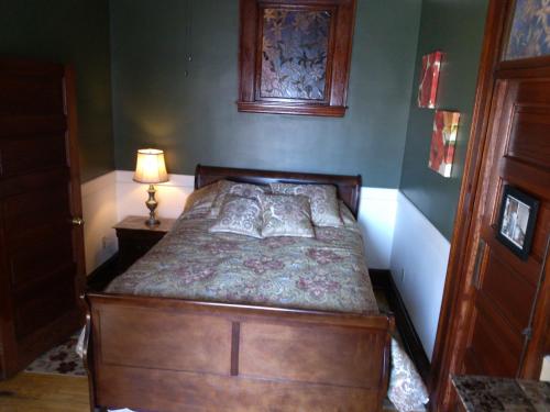 a bedroom with a bed with a dresser and a lamp at Firehouse Inn in Barre