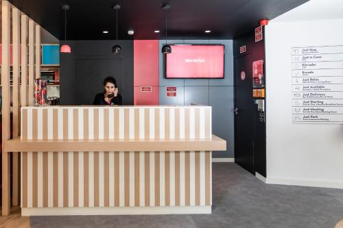 a woman talking on a cell phone behind a counter at Stay Hotel Coimbra Centro in Coimbra