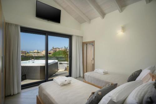 a bedroom with two beds and a balcony with a view at Sun Ray Beach Life Villa in Agia Marina Nea Kydonias