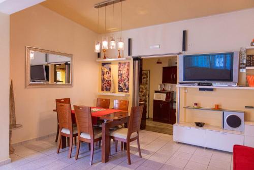 comedor con mesa y TV en Orestis House, en Artemida