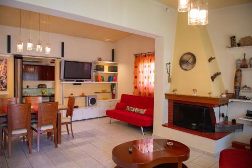 ein Wohnzimmer mit einem roten Sofa und einem Kamin in der Unterkunft Orestis House in Artemida