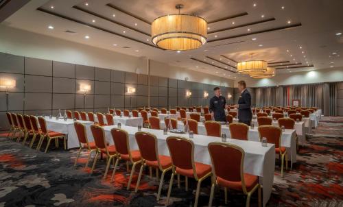 two men standing in a banquet hall with tables and chairs at Clayton Hotel Liffey Valley in Clondalkin 