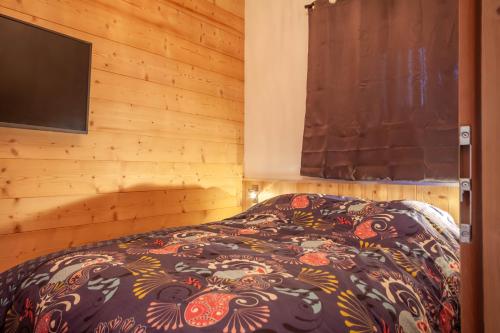 um quarto com uma cama num quarto de madeira em PORTES DU PLENEY 001 em Morzine
