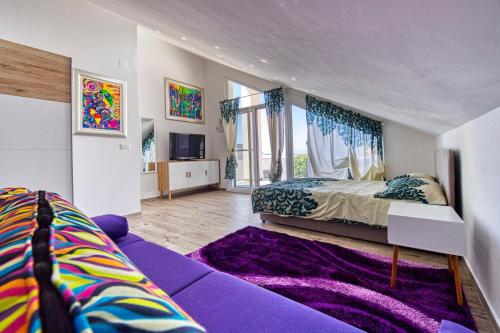 a bedroom with a purple bed and a purple couch at Boutique Villa Nirvana 2, Proboj 25 in Pag