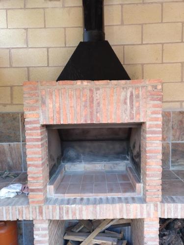 a brick oven sitting on top of a brick wall at La Casita Del Abuelo in Villalmanzo