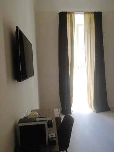 a room with a table with a television and a window at Gatto Bianco Duchessa in Bari