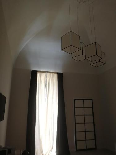 a window with a white curtain and a chandelier at Gatto Bianco Duchessa in Bari