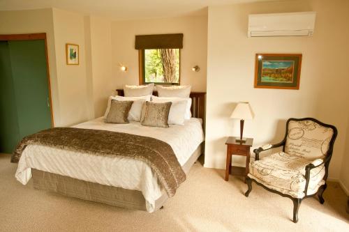 a bedroom with a bed and a chair at Whakaipo Lodge in Taupo