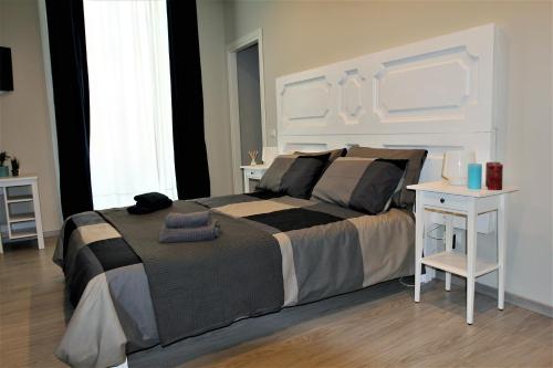 sypialnia z dużym łóżkiem i białym stołem w obiekcie B&B Terre di Catania w Katanii