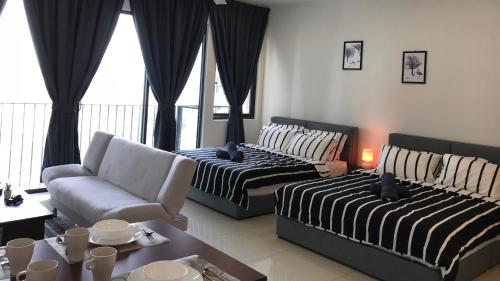 een woonkamer met 2 bedden en een bank bij CozyStudio Trefoil Setia Alam in Shah Alam