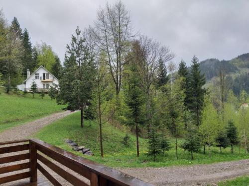 una casa en una colina con una valla de madera en Șoaptele pădurii & Căsuța din pădure, en Suceviţa