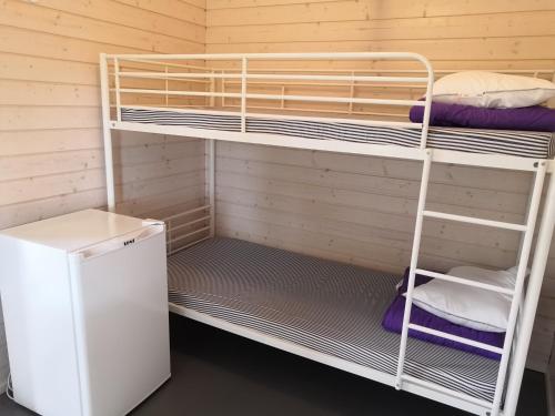 a bunk room with two bunk beds and a refrigerator at Koljonvirta Camping in Iisalmi