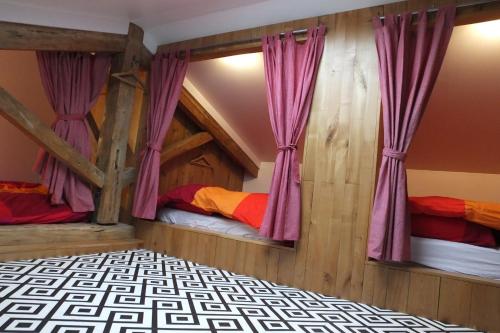 Cognin-les-GorgesにあるGîte Séchoir du Nanのベッドルーム1室(紫色のカーテン付きの二段ベッド2組付)