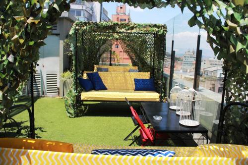 a couch on a balcony with a table and chairs at Hotel Regina in Bogotá