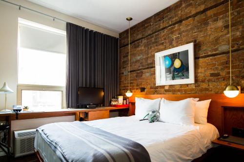 a bedroom with a bed with a teddy bear sitting on it at The Drake Hotel in Toronto