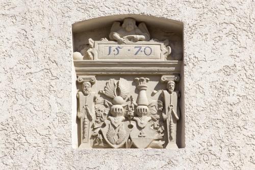 a stone wall with a clock on top of it at Wenkheimer Hof Ferienwohnung in Iphofen