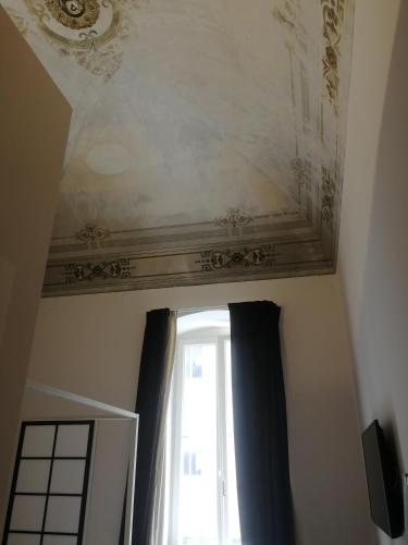 a room with a ceiling and a window with curtains at Gatto Bianco Duchessa in Bari