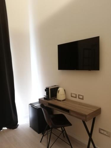 a desk with a microwave and a computer on a wall at Gatto Bianco Duchessa in Bari