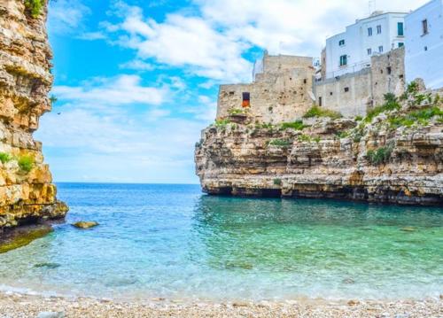 a castle on a cliff next to the ocean at Cà di Rò in Polignano a Mare