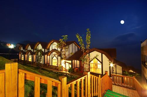 a large house with a wooden fence at night at Sea of Clouds Vacation Villa in Renai