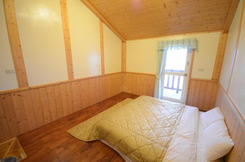 a bedroom with a bed in a room with a window at Sea of Clouds Vacation Villa in Renai