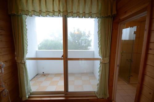 a large window in a room with a bathroom at Sea of Clouds Vacation Villa in Renai