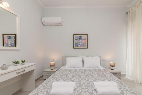 ein weißes Schlafzimmer mit einem großen Bett mit zwei Lampen in der Unterkunft Sea La Vie Villa in Zakynthos