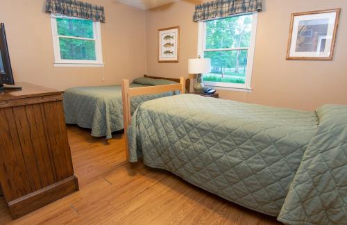 a bedroom with two beds and a flat screen tv at Carter Caves State Resort Park in Olive Hill