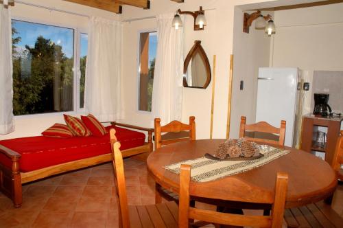 uma sala de estar com uma mesa e um sofá em Puente Austral em San Carlos de Bariloche