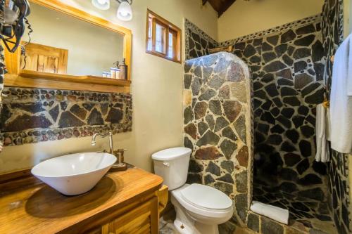 a bathroom with a sink and a toilet and a mirror at Hotel Santa Catalina Panamá in Santa Catalina