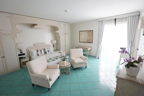 a living room with a bed and two chairs at Grand Hotel Terme in Margherita di Savoia
