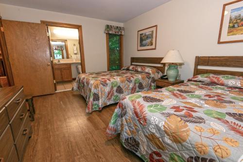 a hotel room with two beds and a bathroom at Carter Caves State Resort Park in Olive Hill