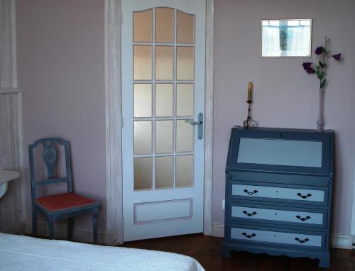 a bedroom with a blue dresser and a blue door at Maison d'hôtes La Tuilerie in Peschadoires