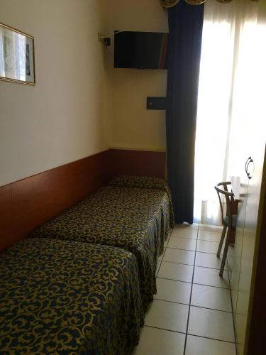 a small bedroom with a bed and a window at Hotel Lido in Lido di Jesolo