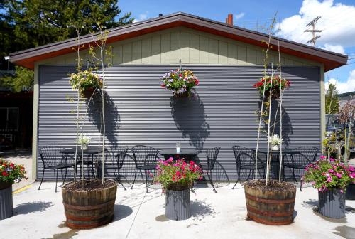 a patio with tables and chairs and flowers in barrels at Moose Creek Inn in West Yellowstone