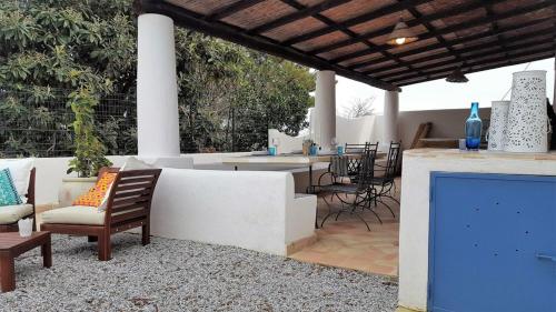 a patio with a couch and chairs and a table at Villa Euribia in Santa Marina Salina