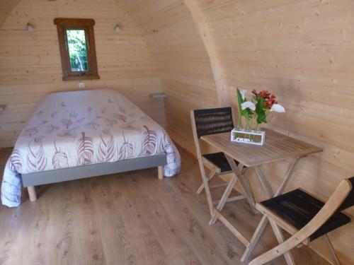 a bedroom with a bed and a table and chairs at L'eden naturiste spas in Challans
