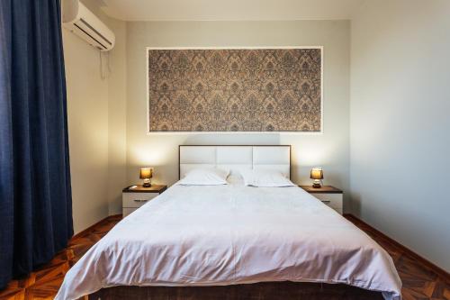 a bedroom with a white bed with two night stands at Memory House in Kutaisi