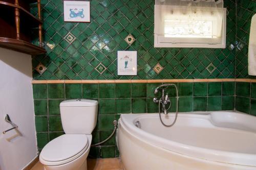 a green tiled bathroom with a toilet and a tub at Corfu Town Mini Villa Private Pool Gardens in Mantoúkion