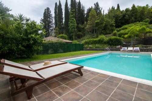 a swimming pool with a chaise lounge next to at Corfu Town Mini Villa Private Pool Gardens in Mantoúkion