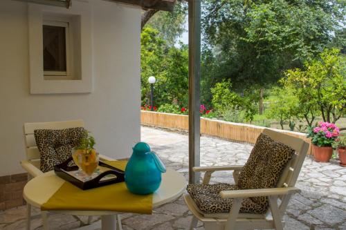 a patio with a table and chairs and a window at Corfu Town Mini Villa Private Pool Gardens in Mantoúkion