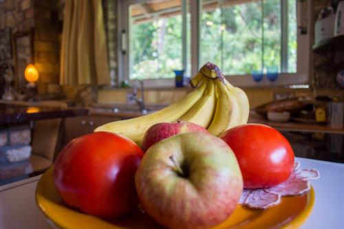 a bowl of apples and bananas on a counter at Corfu Town Mini Villa Private Pool Gardens in Mantoúkion