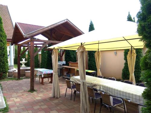 a patio with a pavilion and tables and chairs at Koppi Ház in Siófok