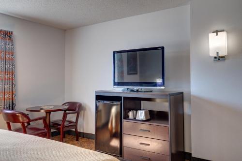 a hotel room with a bed and a flat screen tv at Howard Johnson by Wyndham Branson Theatre District in Branson
