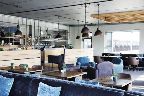 a restaurant with tables and chairs and a bar at Fosshotel Nupar in Kálfafell