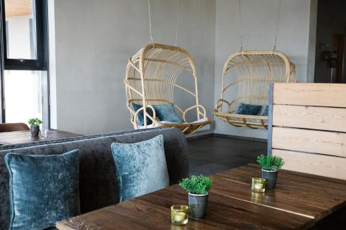 a living room with a couch and two wicker chairs at Fosshotel Nupar in Kálfafell